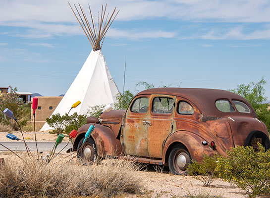 Rusted car and teepee.